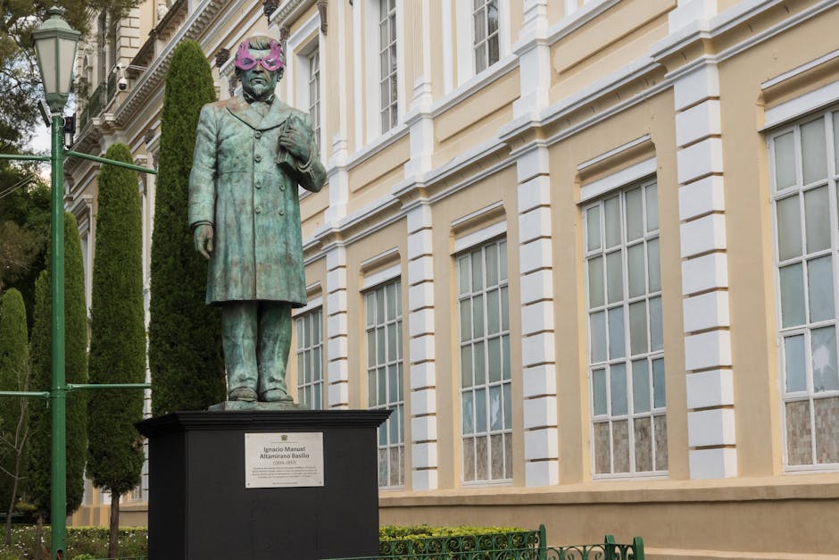 Bronze statue of Ignacio Manuel Altamirano adorned with purple glasses in Toluca, Mexico.