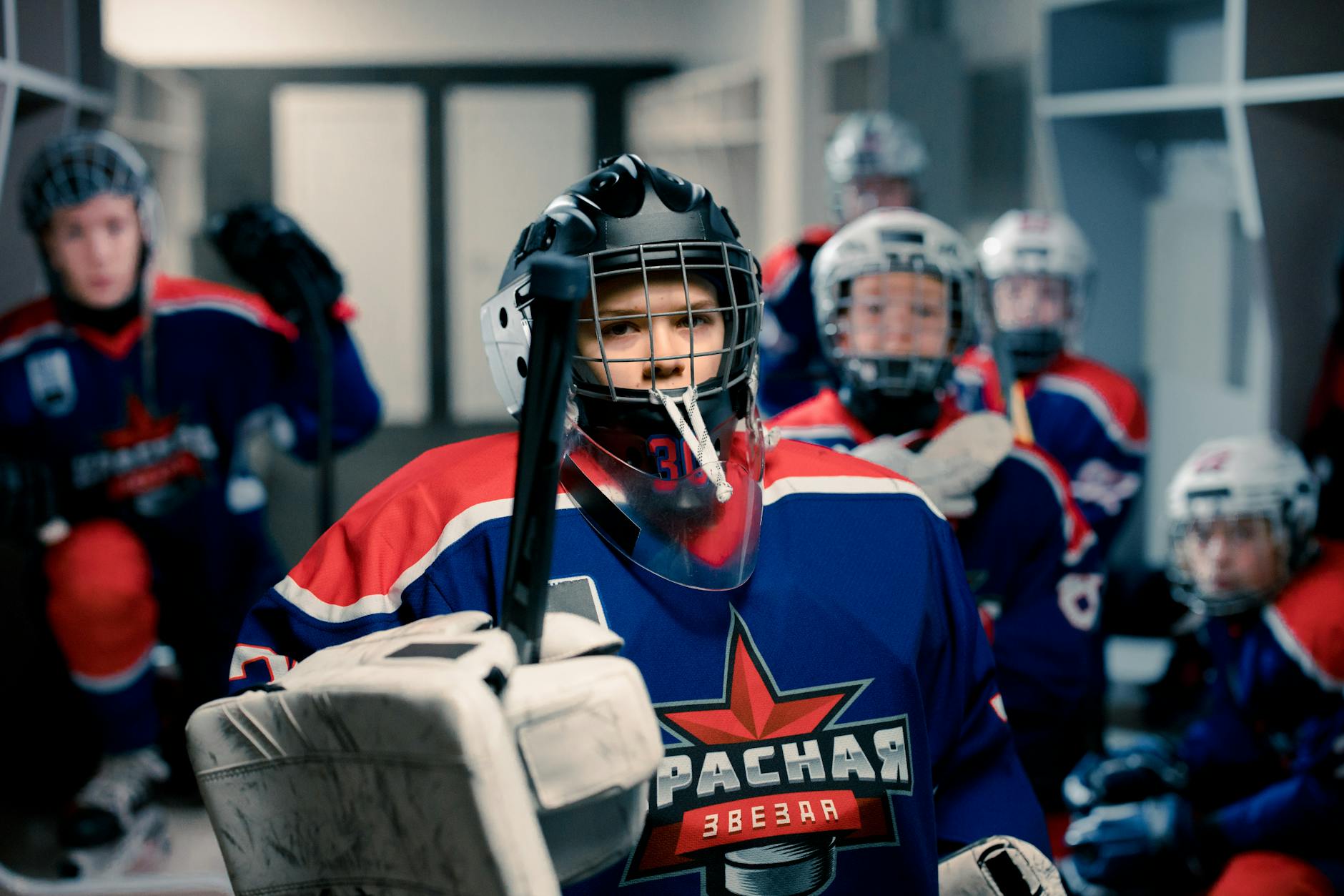 Young ice hockey players geared up in dressing room, ready for game. Team spirit and readiness.
